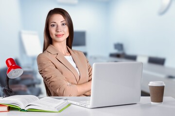 Cheerful businesswoman at desk in office with computer