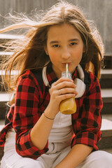 cool girl holding juice bottle outdoors