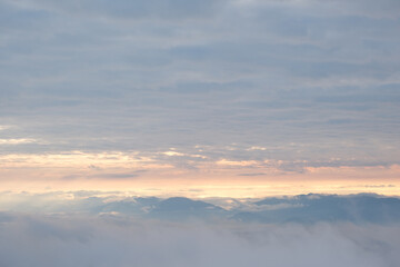 A mountain obscured by white mist at dawn