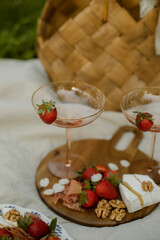 cocktail transparent glass decorated with strawberries close-up. snacks close-up. brie cheese, walnut, strawberry, and ham slices.
