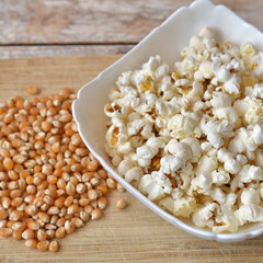 Popcorn home cooking and corn seeds on wooden background