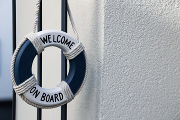 Obraz premium Toy ring buoy hanging on metal fence, closeup