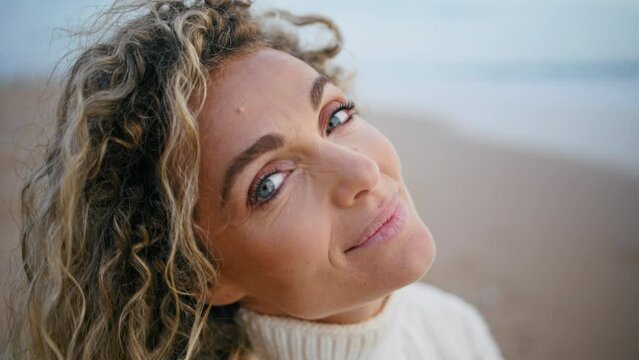 Romantic woman posing beach on autumn weekend closeup. Smiling curly model enjoy