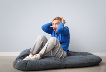 Scared mature woman on light background