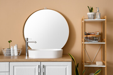 Interior of modern bathroom with sink, mirror and shelving unit