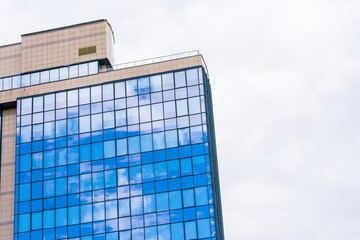 Glass Tower with a Stunning Blue windows and White Clouds reflections