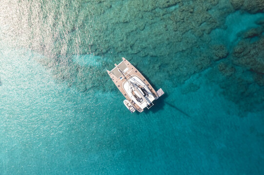 Overhead view of catamaran floating on tropical rippling sea