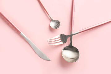 Stylish cutlery on pink background