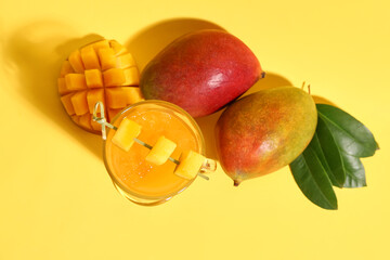 Glass of fresh mango smoothie on orange background