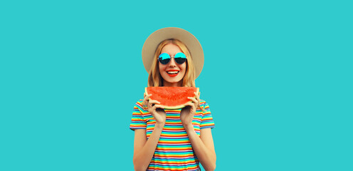 Summer portrait of happy smiling young woman with fresh juicy slice of watermelon wearing straw hat on blue background