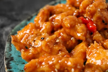 Plate with tasty sweet and sour chicken on table, closeup