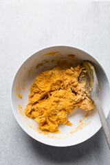 Loosely folded cheddar cheese bread dough in a white bowl, process of making bread