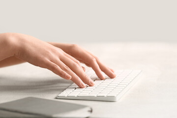 Female programmer using computer keyboard on light table, closeup