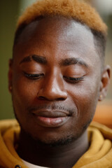 Fototapeta premium Emotional young black guy in yellow casual raising with smartphone