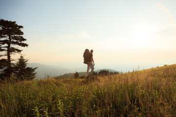 Adventurous man backpacking and hiking while taking in the view of the mountains