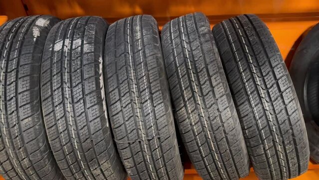 Car tires in a tire shop. Warehouse of tires for the automotive industry. New car tires. Concept of car service, wheel change, tire shop. Tires for sale. Seasonal car rubber