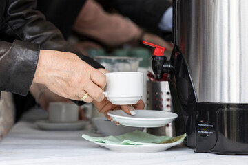 Frau füllt am Buffet Kaffee in eine Tasse