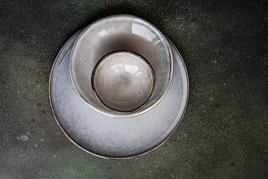 Overhead view of grey ceramic bowls and plates on a table