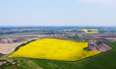 Aerial view of the yellow agricultural agro fields of rapeseed plant culture. Photography for the background of tourism, design, advertising and agro business