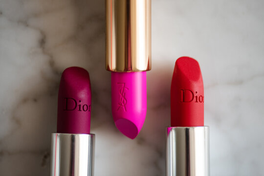Moscow, Russia - May 17, 2023: Yves Saint Laurent and Dior lipstick in pink and red shade closeup top view. Beauty products.
