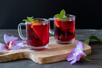 Red Hot Hibiscus tea in a glass mug on a wooden table 