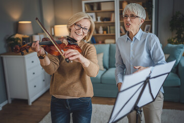 Private music teacher give violin lesson mature senior woman at home