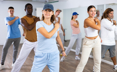 Obraz premium Group of energetic different people learning dance at dance class