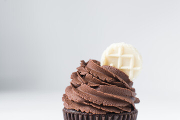 Chocolate cupcake with dark chocolate buttercream, double chocolate cupcakes with american buttercream, tall swirl frosting on a cupcake with a wafer
