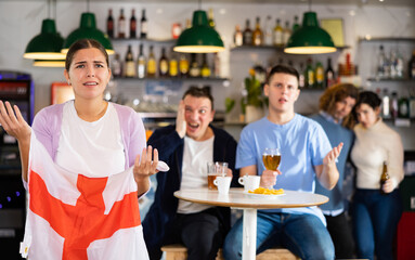 Group of fans of England team are upset by oss of their favorite team and express negative emotions in a beer bar