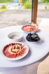 Dish with Iberico ham cut ready to eat. Ham cutter man. Service of a person cutting a piece of ham. traditional food of spain