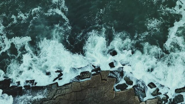 White waves of the Atlantic Ocean crashing against a rocky shore 4k
