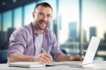 Portrait of young businessman inside office work on laptop