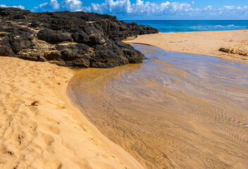 Small Stream Flowing Across Lava Reef,  Kauapea Beach (Secret Beach), Kauai, Hawaii, USA