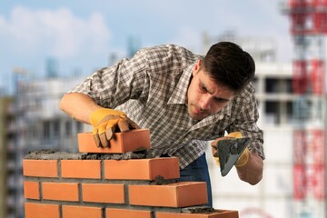 Young builder man during work at factory workplace.