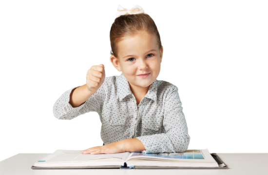 Confident elementary-aged schoolgirl sitting at the desk