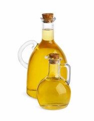 Glass jugs of cooking oil on white background