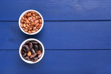 Different kinds of dry kidney beans on blue wooden table, top view. Space for text