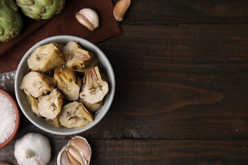 Pickled and fresh artichokes on wooden table, flat lay. Space for text