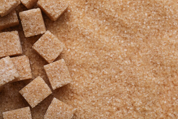 Different types of brown sugar as background, top view