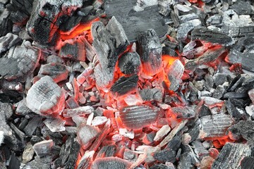 Many smoldering coals as background, closeup view