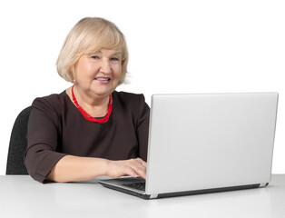 Old Woman Sitting behind Table and Typing on a Laptop - Isolated