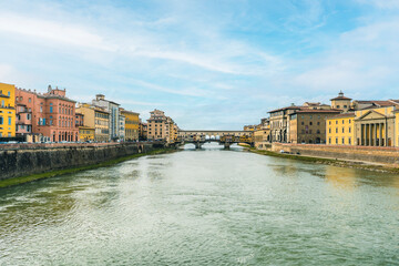 Fototapeta na wymiar Landscape of Arno River and Ponte Vecchio, in Florence, Italy. Far away, Ponte Vecchio