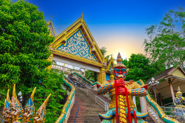 Demon Defender at a Beautiful Wat Buddhist temples in Old Phuket town Thailand. Decorated in beautiful ornate colours of red and Gold and Blue. Khao Rang Hill