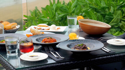 Dinner in beach restaurant with sea view. Restaurant with served table with delicious food in seafront of Phuket island. Romantic dinner for two