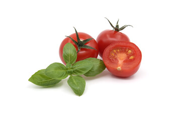 Tomato and green basil leaves isolated on white background