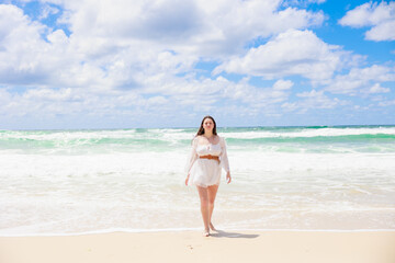 海辺を歩く白いドレスの白人の少女