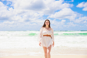 Fototapeta na wymiar 海辺を歩く白いドレスの白人の少女