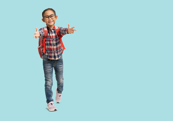 School girl, Happy smiling Asian student school kid pointing with carry a bag, Full body portrait isolated on pastel plain light blue background