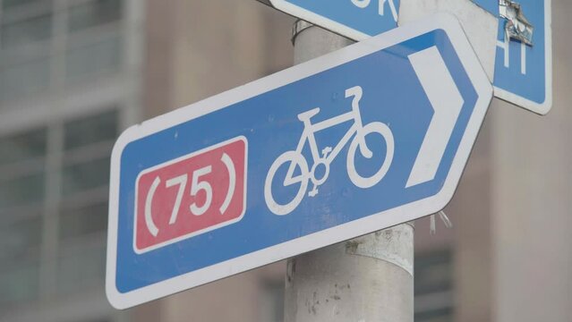 Blue, white and red bicycle sign indicating how far to next cycle lane