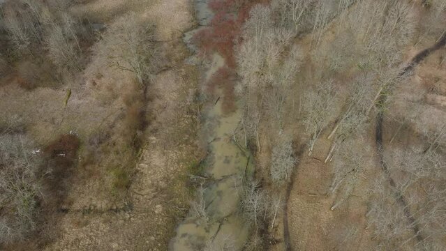 Aerial view of high water in springtime, flood, Durbe river (Latvia), Cirava city, brown and muddy water, sunny day, wide drone birdseye shot moving forward